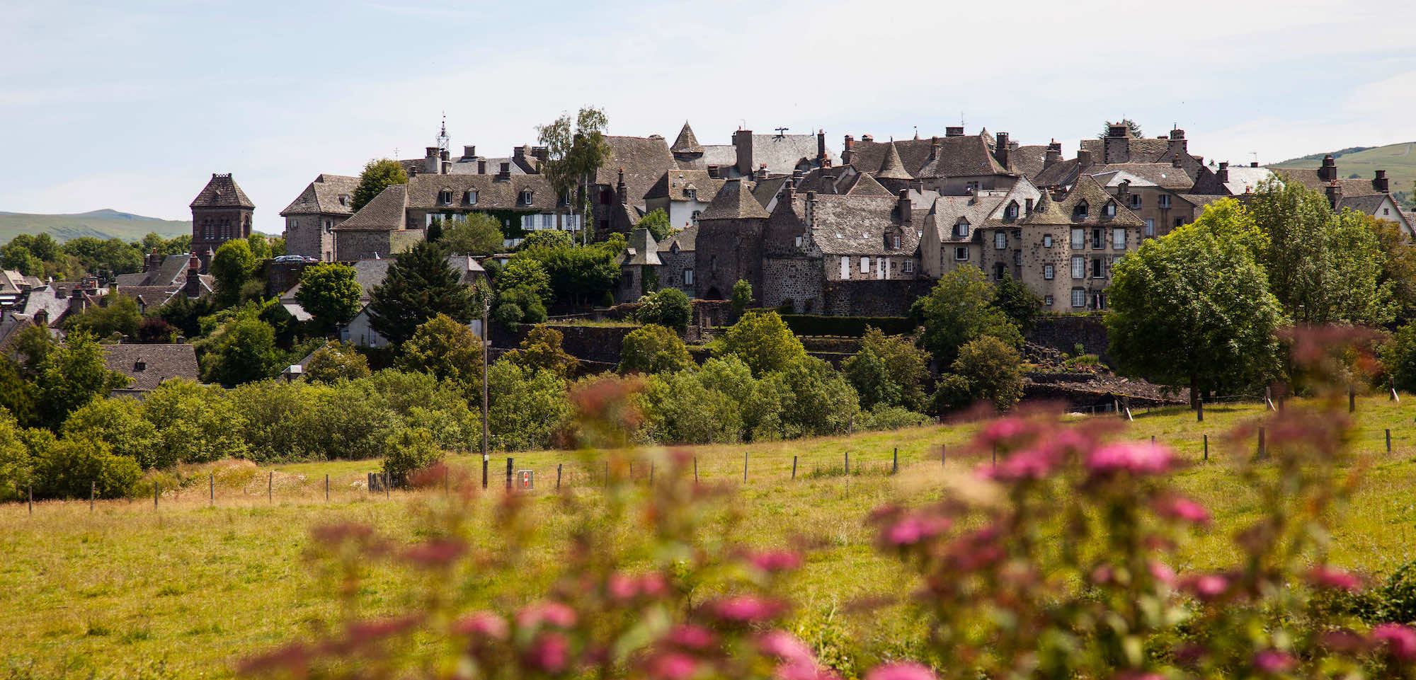Dit dorp in de Cantal met zijn zwarte huizen is een van de mooiste dorpen in Frankrijk background poster